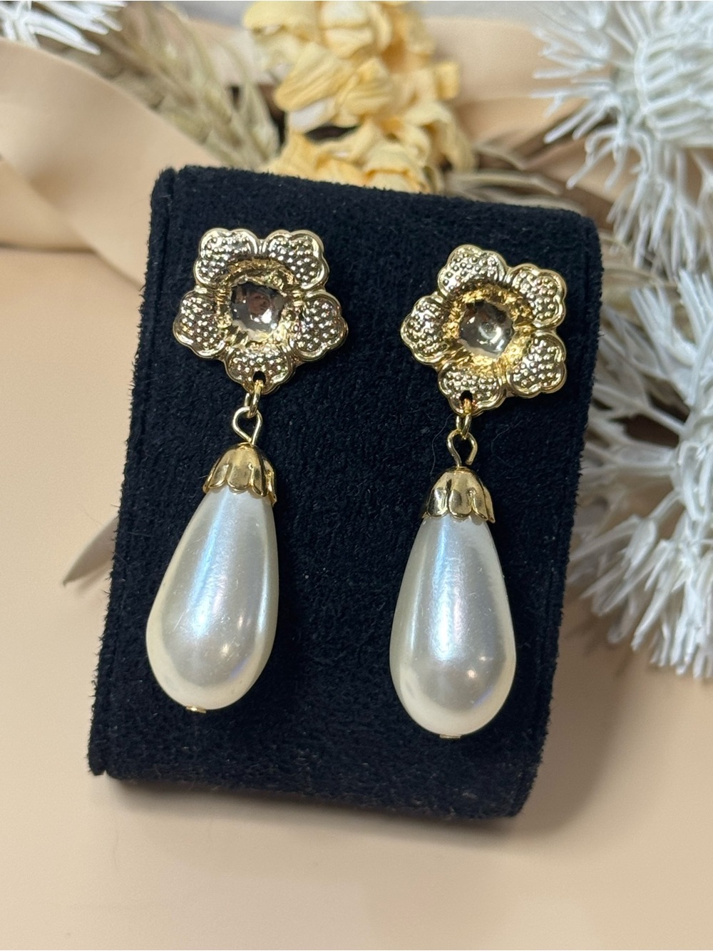 Vintage pierced earrings featuring sculptural gold tone swirl tops with large cr